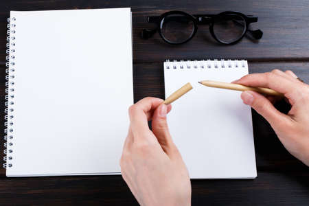 hand holding beige pen pencil with mock up design. office style work spaceの写真素材