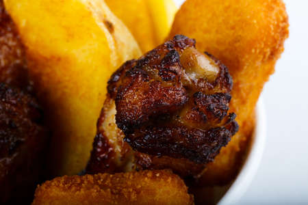 fried potato and chicken leg on white background top view. Quail grilled thighs and potatoes.