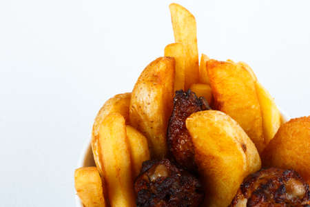 fried potato and chicken leg on white background top view. Quail grilled thighs and potatoes.の写真素材
