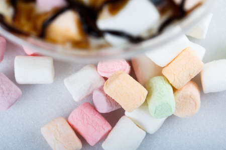 Spilled colored marshmallows from a mug on white  background close upの写真素材