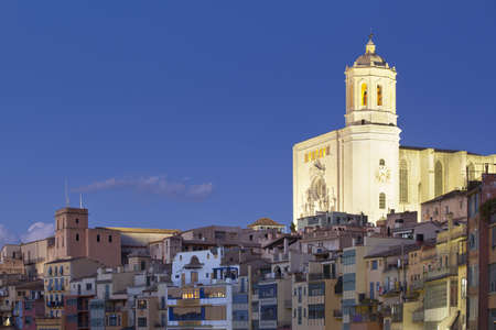 View of the Girona Cathedral at night, with the Onyar colorful houses.の写真素材
