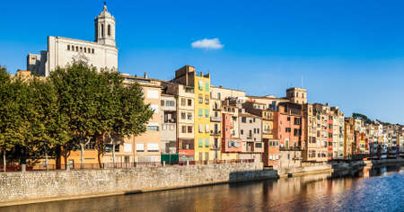 Urban landscape of Girona with it great Cathedral and colorful river houses.の写真素材