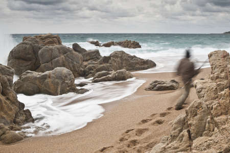 A lonely man is going to fish through the rough sea.