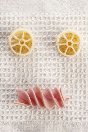 Funny pasta face with italian raw handmade pasta.の写真素材