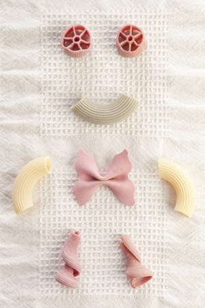 Pieces of raw pasta making a funny doll.