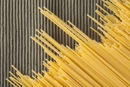 Composition with italian raw spaghetti making diagonals on a green napkin.の写真素材