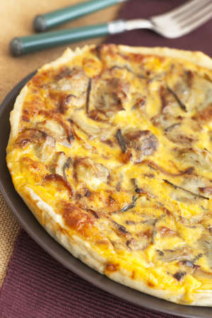 Delicious asparagus and artichoke  homemade quiche on a brown dish.の写真素材