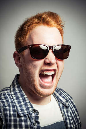 Young redhead is screaming very loud.の写真素材