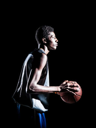 Young basketball player isolated on black の写真素材