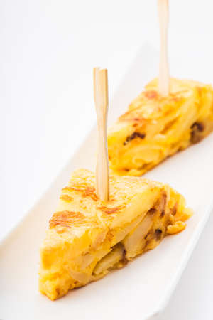 Spanish tapas. Tortilla de patatas toothpick isolated on white backround.の写真素材
