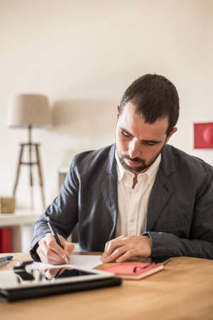 Young businessman working in his modern office.の写真素材
