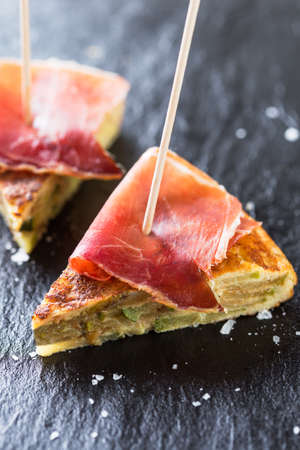 Typical spanish tapas: Tortilla de patatas with serrano ham.の写真素材