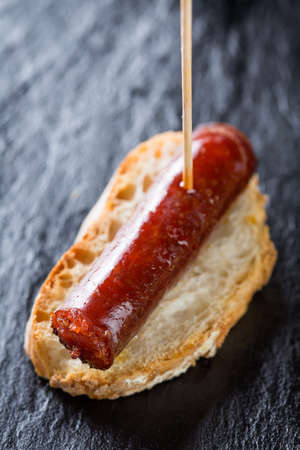 Typical spanish tapas: Delicious pork sausage called chistorra.の写真素材