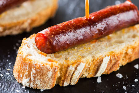 Typical spanish tapas: Delicious pork sausage called chistorra.の写真素材