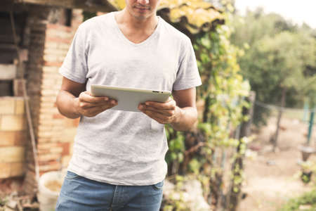 Young man using tablet in rural outdoor.の写真素材