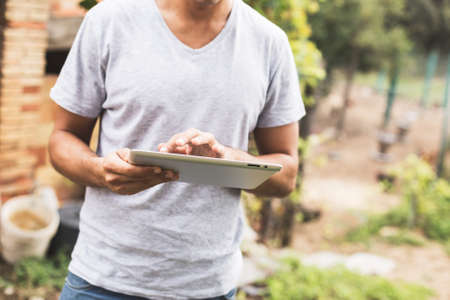 Young man using tablet in rural outdoor.の写真素材