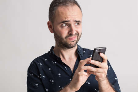 Man holding a phone with funny expression.