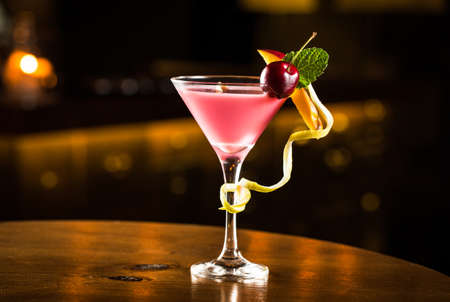 Pink cocktail with cherry and mango in a club.の写真素材