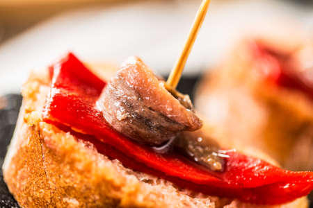 Red peppers with great anchovies on a slice of bread. Typical spanish food. Detail.の写真素材