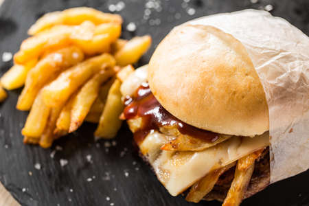 Street burger stuffed with cheese, potatoes and ketcgup sauce.の写真素材