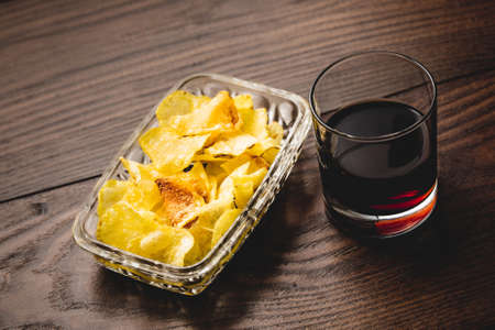Classic spanish vermouth with chip potatoes on a wooden table.の写真素材