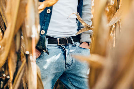 Young man standing in the middle of cornfieldの写真素材