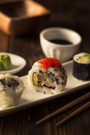 Fresh and delicious maki sushi  with soy sauce on a dark wooden table.の写真素材