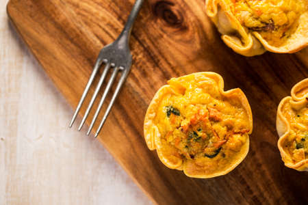 Carrot vegan quiche on wooden board with fork. From aboveの写真素材