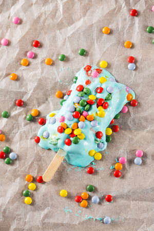 Melting ice cream covered with candiesの写真素材