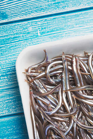 Fresh sand eel fish on a wooden table.の写真素材