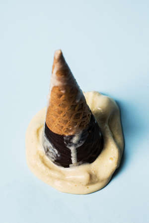 Vanilla ice cream cone isolated on blue background.