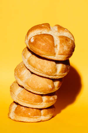 Delicious fresh pile of buns isolated on yellow background.の写真素材