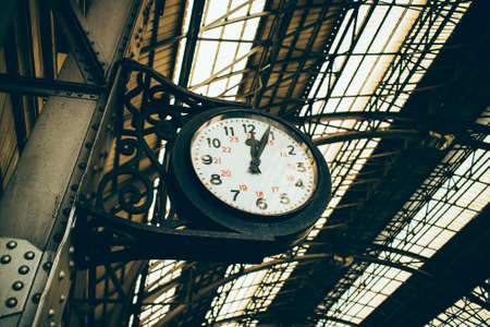 low perspective of old black clock at railroad stationの写真素材