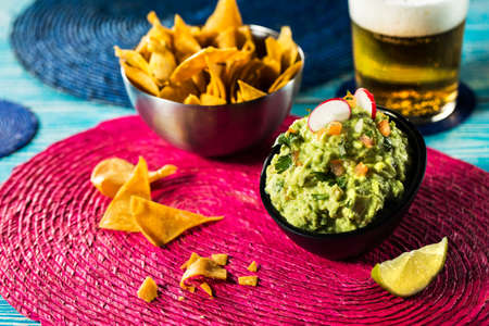 Tasty mexican nachos with fresh guacamole and beer.の写真素材