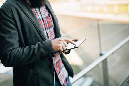 Crop faceless shot of male hands holding and using tablet.の写真素材