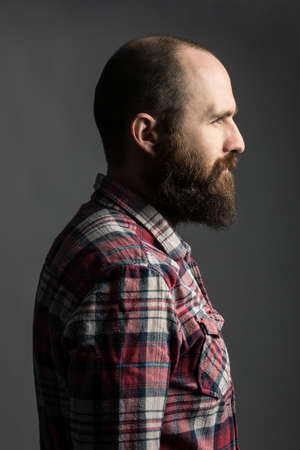 Studio shot of baearded hipster looking away pensively.の写真素材