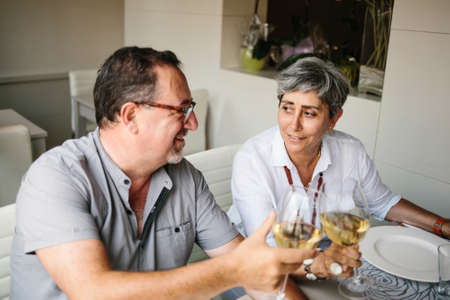 Laughing mature couple sitting at table in restaurantの写真素材