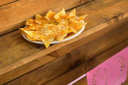 Close-up shot of delicious nacho chips with cheese served on plate in a food truck.の写真素材