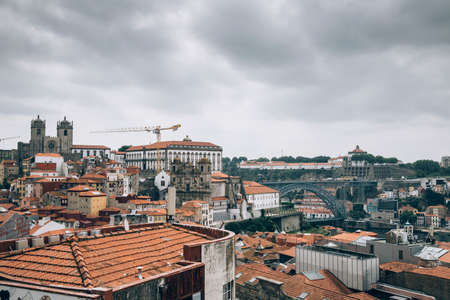 Aerial view of orange tiled rooftops of old city of Oporto in morning mist, Portugal.の写真素材