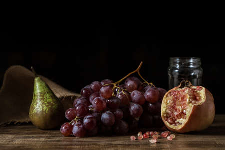 Pictorial still life with grapes, pears and pomegranate.の写真素材