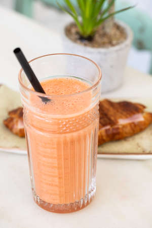 Fresh strawberry smoothie on a white table, copy space.