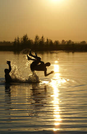 Jumping to the water at sunriseの写真素材