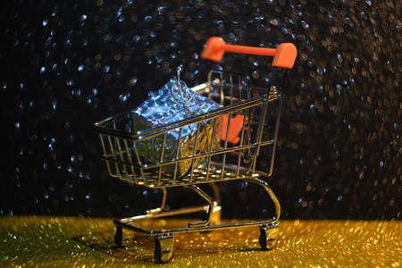 Shiny packaging in shopping cart with bokeh.の写真素材