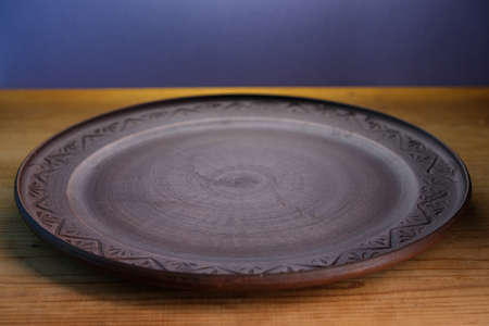 Brown plate on a wooden surface.の写真素材