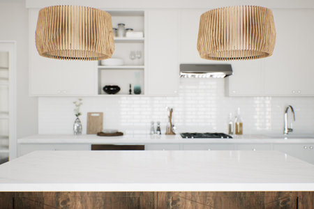 Focus on the marble countertop against the backdrop of kitchen appliances and utensils.の写真素材