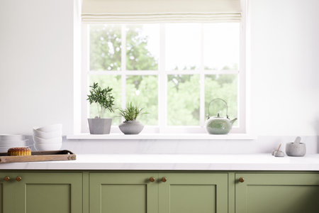 A tranquil green kitchen filled with plants and abundant natural light creates a calming atmosphereの写真素材
