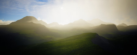 Lush green hills flourish under a bright blue sky filled with beautiful, fluffy cloudsの写真素材