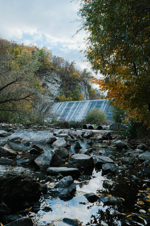 A Serene and Majestic Waterfall Wonderfully Nestled Amidst a Beautifully Vibrant Autumn Landscapeの写真素材
