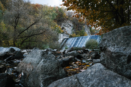 A Serene and Majestic Waterfall Wonderfully Nestled Amidst a Beautifully Vibrant Autumn Landscapeの写真素材