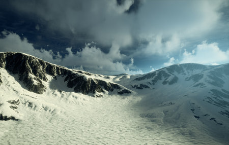Behold the Majestic Aerial View of the SnowCapped Mountains Beneath a Clear Blue Skyの写真素材
